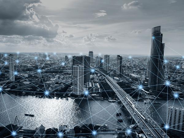An aerial view of a bustling city, where modern skyscrapers rise above a shimmering river, interconnected by a network of light, symbolizing the flow of ideas and technology in an ever-evolving urban landscape.