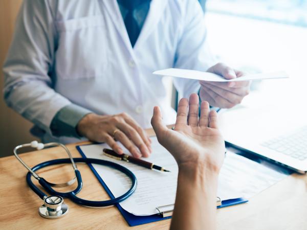 In a modern clinic, a doctor hands over important health documents to a patient, symbolizing the transfer of knowledge and care. The warm and inviting atmosphere reassures the patient as they prepare to embark on their health journey.
