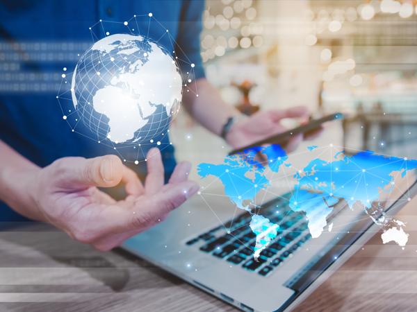 A professional navigating the digital landscape, balancing technology and global connections. The world map illuminates possibilities as innovative solutions unfold at their fingertips.